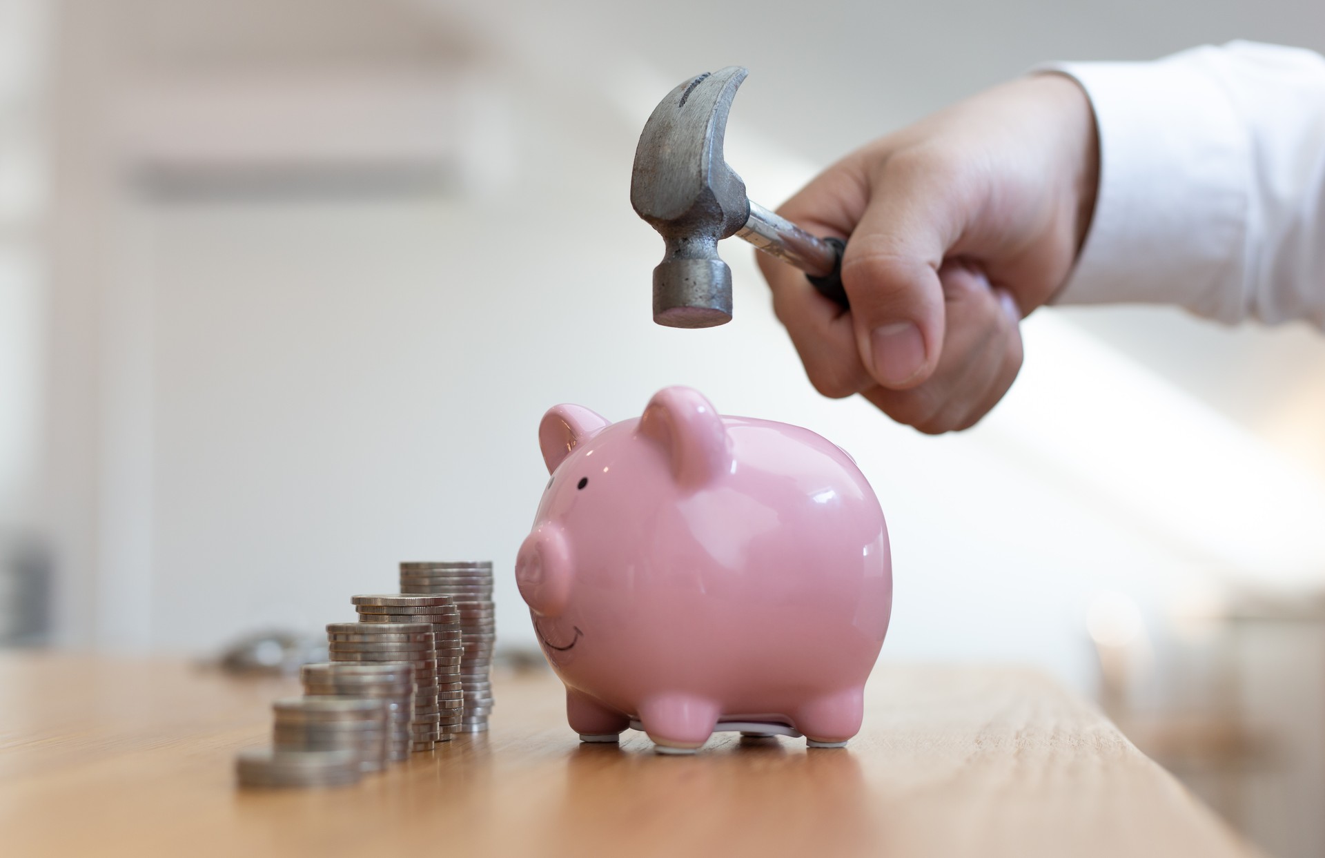 Emergency finance, Businessman using a hammer is about to destroy the pink piggy bank, Reserve money concept